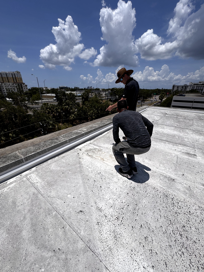 Two roofers working on a flat roof